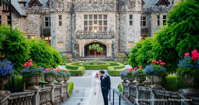 A newlywed couple posing for a picture in front of Hatley Castle