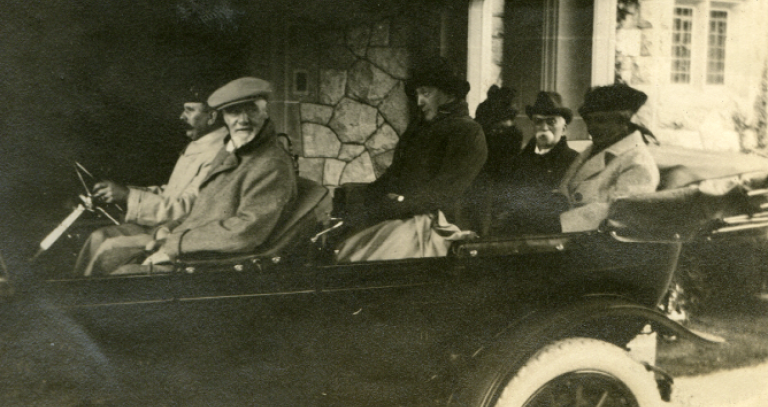 Archival photo: Passengers riding in old-fashioned car in front of Hatley Castle